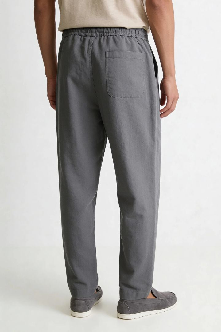 Men wearing gray linen drawstring trousers relaxed straight fit lightweight summer linen pants back view