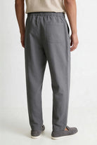 Men wearing gray linen drawstring trousers relaxed straight fit lightweight summer linen pants back view