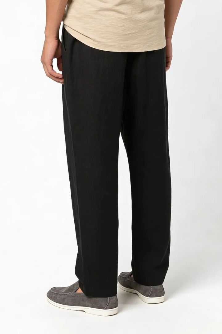Men wearing black linen drawstring trousers relaxed straight fit lightweight summer linen pants back view